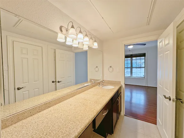 a spacious bathroom with a granite countertop sink a light fixture and a mirror