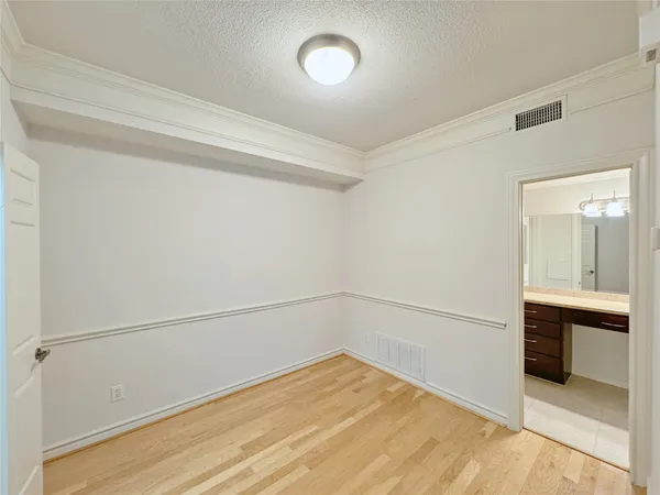 a view of an empty room with cabinet and a window