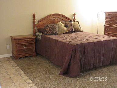 219 Larkspur Street Ridgecrest, CA 93555 - Photo 18 of 34 a bedroom with a bed and a night stand