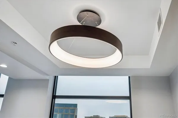 a kitchen with stainless steel appliances granite countertop a stove top oven a refrigerator a kitchen island and chairs with wooden floor