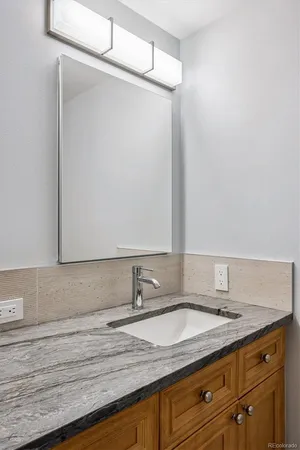 a bathroom with a granite countertop sink and a mirror