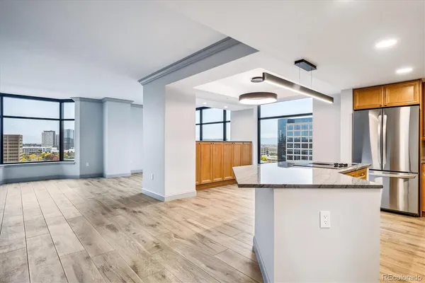 a room with kitchen island a sink wooden floor and glass door