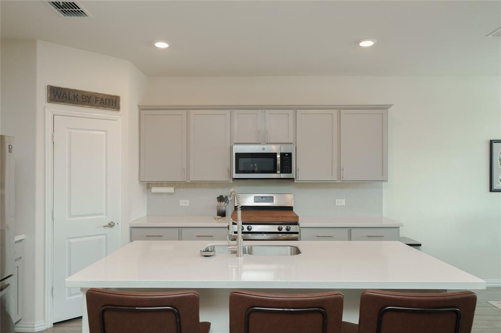 677 Ridgeback Trail Fort Worth, TX 76052 - Photo 15 of 40 a kitchen with a sink a stove and cabinets