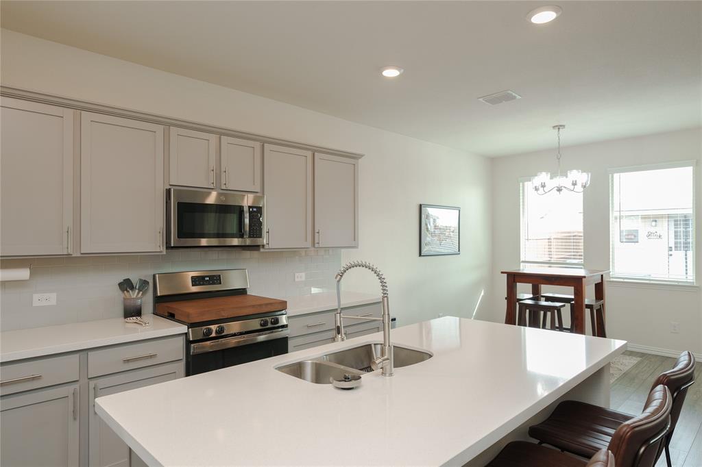 677 Ridgeback Trail Fort Worth, TX 76052 - Photo 16 of 40 a kitchen with sink a microwave and cabinets