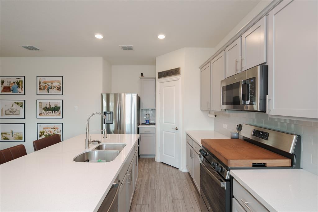 677 Ridgeback Trail Fort Worth, TX 76052 - Photo 17 of 40 a kitchen that has a sink and a stove in it
