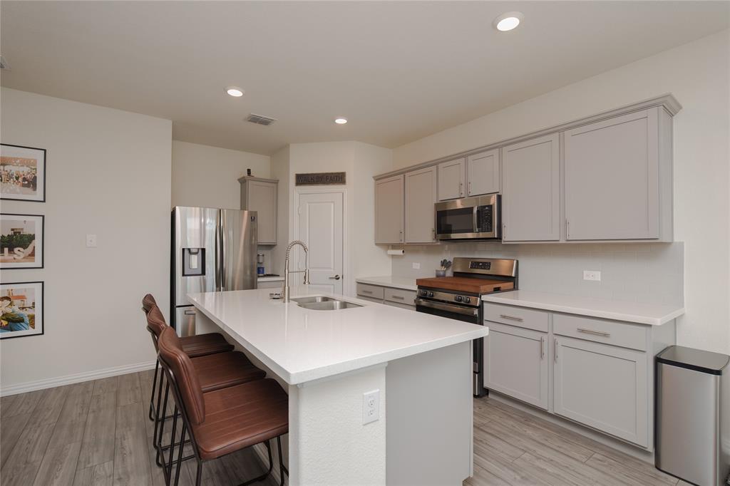 677 Ridgeback Trail Fort Worth, TX 76052 - Photo 19 of 40 a kitchen with stainless steel appliances a microwave sink and refrigerator