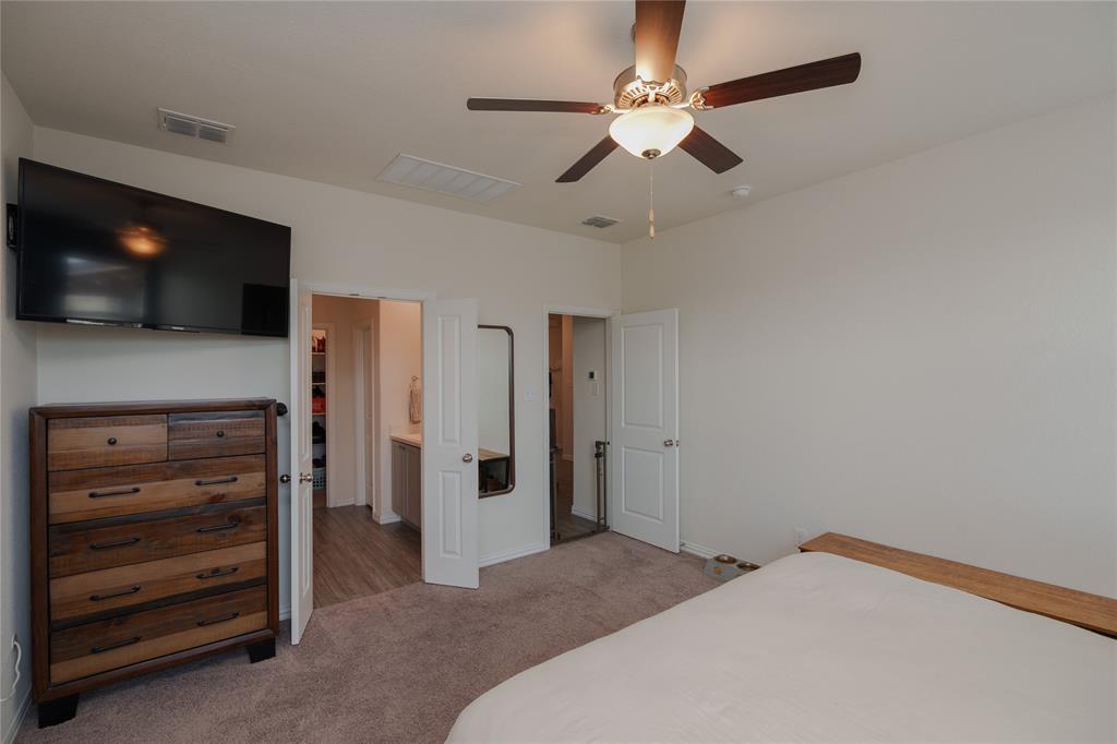 677 Ridgeback Trail Fort Worth, TX 76052 - Photo 25 of 40 a bedroom with a bed and a flat screen tv