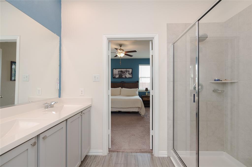 677 Ridgeback Trail Fort Worth, TX 76052 - Photo 28 of 40 a en suite bathroom with a sink a mirror and a shower