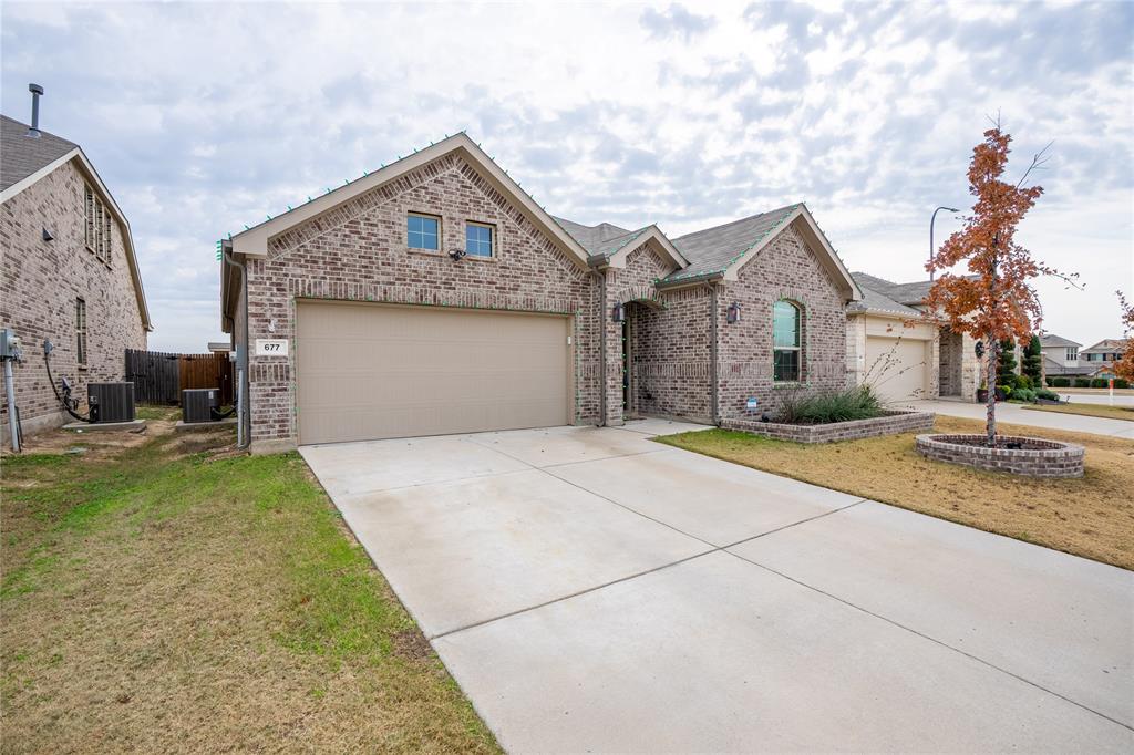 677 Ridgeback Trail Fort Worth, TX 76052 - Photo 3 of 40 a front view of a house with a yard and garage