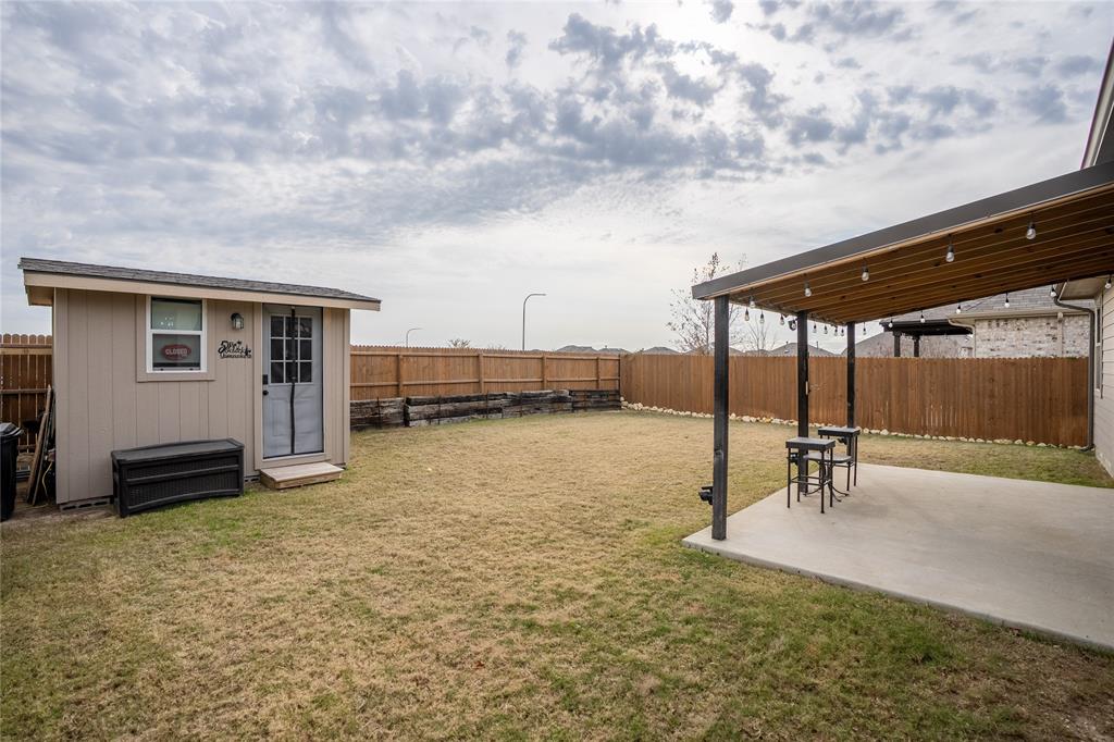 677 Ridgeback Trail Fort Worth, TX 76052 - Photo 33 of 40 a backyard of a house with barbeque oven table and chairs