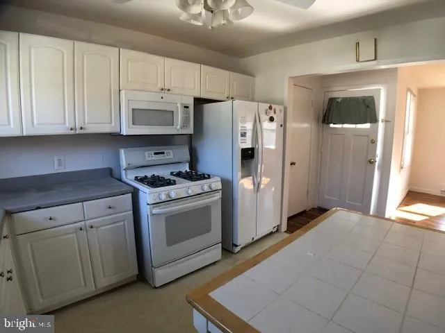 a kitchen with white cabinets and white appliances