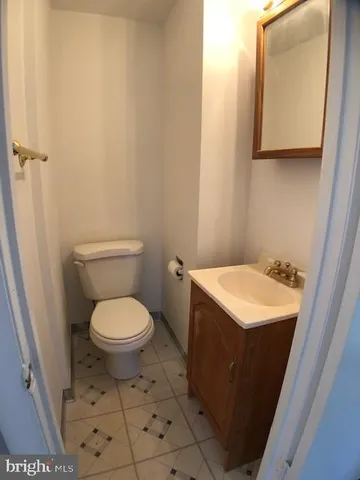 a bathroom with a toilet a sink and mirror