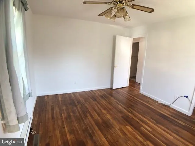a view of a livingroom with wooden floor and a ceiling fan