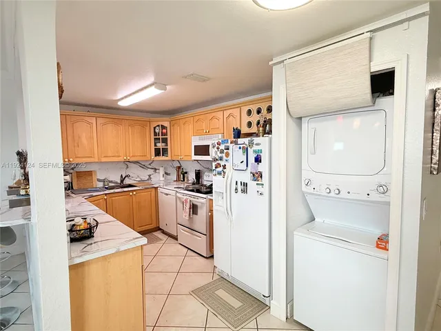 a kitchen with a refrigerator sink and cabinets