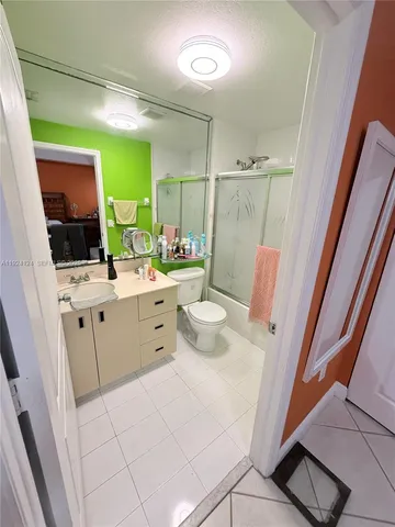 a room with a sink toilet and mirror