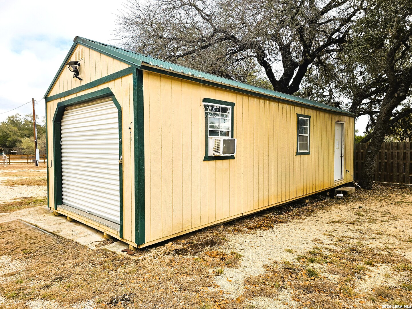 605 Lakeshore Lane Bandera, TX 78003 - Photo 19 of 32 a backyard of a house with wooden fence and large windows
