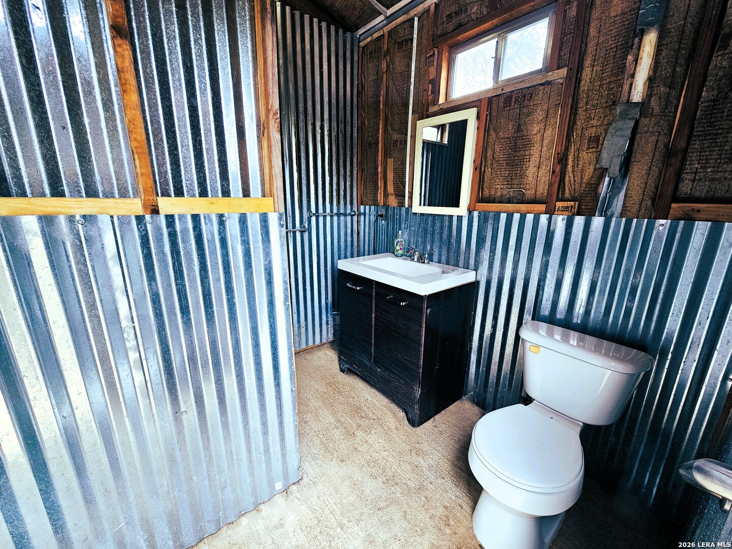605 Lakeshore Lane Bandera, TX 78003 - Photo 9 of 32 a bathroom with a toilet sink and mirror