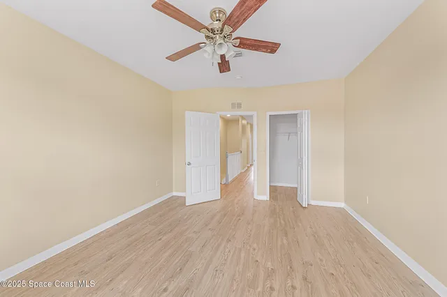 a view of a hallway with wooden floor and entryway