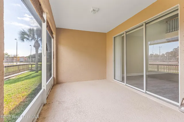 a view of a livingroom with a chandelier fan and windows