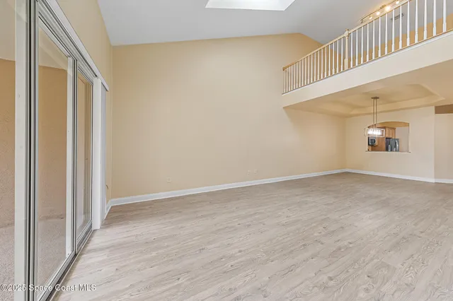 a view of an empty room with wooden floor