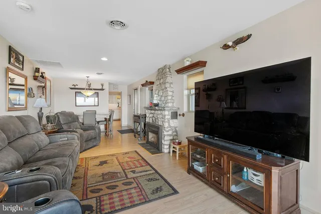 a living room with furniture wooden floor and a flat screen tv