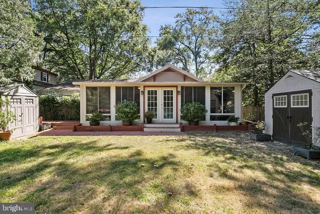 a view of a backyard with wooden fence and trees