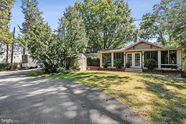 a backyard of a house with table and chairs under an umbrella