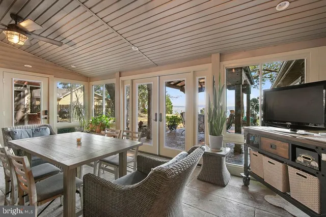 a living room with furniture a flat screen tv and floor to ceiling window