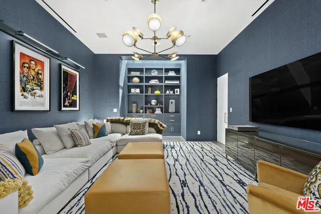 a living room with furniture a flat screen tv and a chandelier