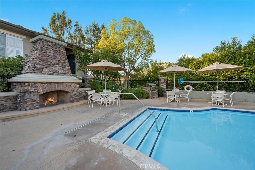 20000 Plum Canyon Road, Unit 316 Saugus, CA 91350 - Photo 22 of 27 a view of a patio with a table and chairs under an umbrella