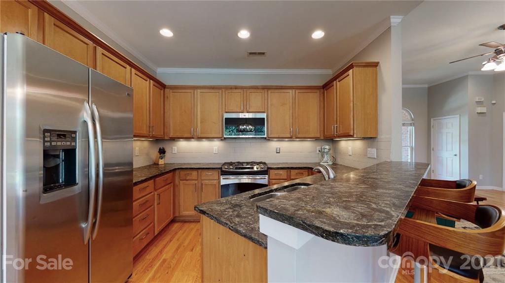 5725 Brookhaven Road Charlotte, NC 28210 - Photo 21 of 39 a kitchen with granite countertop stainless steel appliances and wooden cabinets