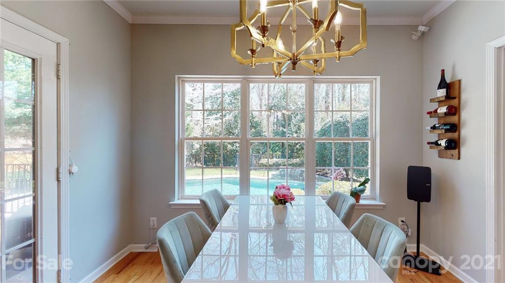 5725 Brookhaven Road Charlotte, NC 28210 - Photo 22 of 39 a view of a dining room with furniture a chandelier and wooden floor