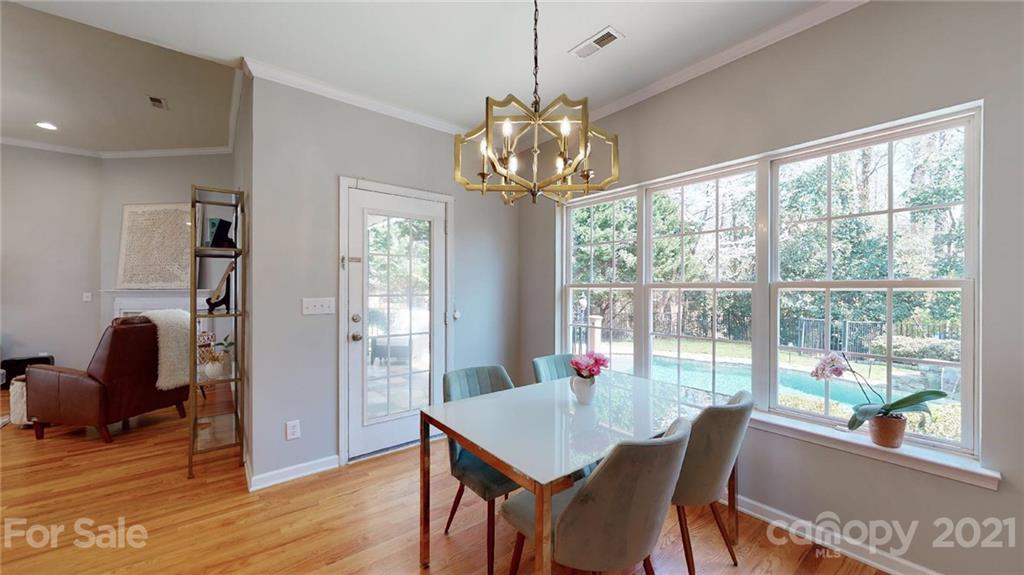 5725 Brookhaven Road Charlotte, NC 28210 - Photo 23 of 39 a view of a dining room with furniture a chandelier and wooden floor