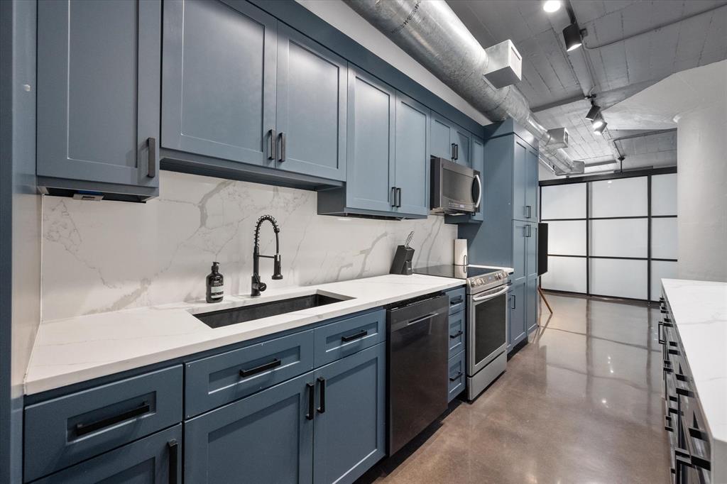 a kitchen with stainless steel appliances granite countertop a sink a stove and cabinets
