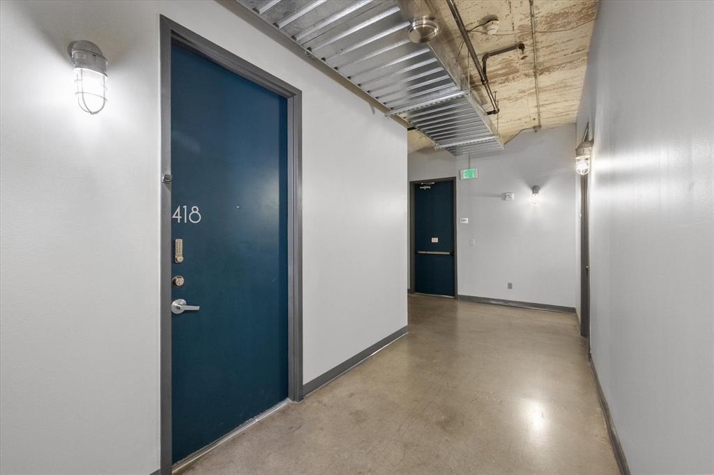 1122 Jackson Street, Unit 418 Dallas, TX 75202 - Photo 15 of 23 a view of a hallway with wooden shelves