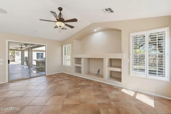 a view of an empty room with a window and a kitchen