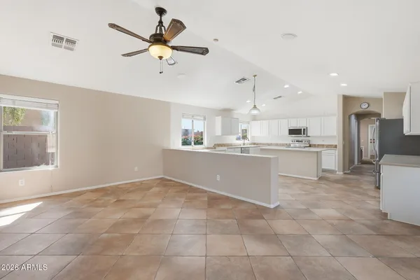 a view of a kitchen with kitchen island wooden floor and a ceiling fan