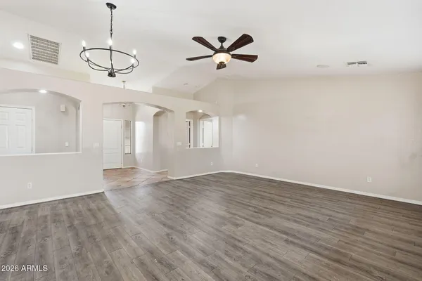 a view of a room with wooden floor and ceiling fan