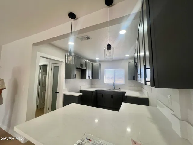 a large kitchen with kitchen island a large counter space a sink appliances and cabinets