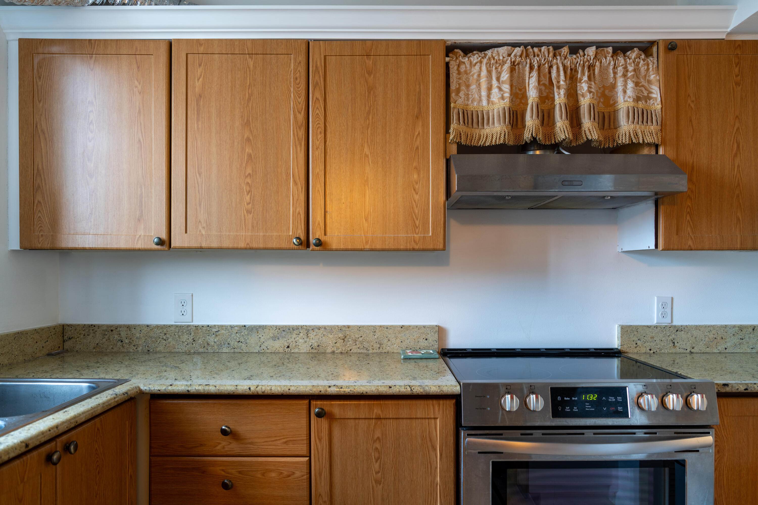 400 Ocean Trail Way, Unit 101 Jupiter, FL 33477 - Photo 12 of 21 a kitchen with granite countertop cabinets and black appliances