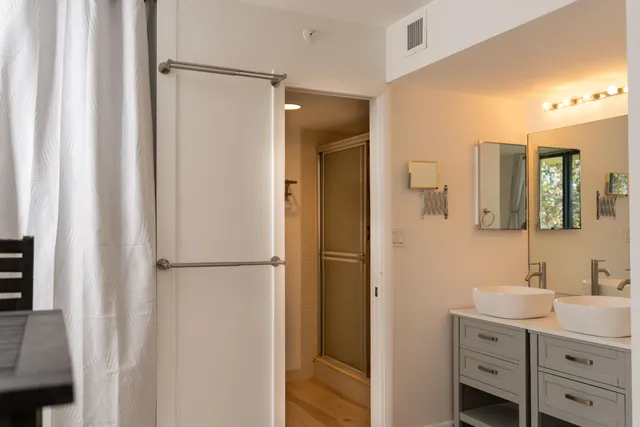 a bathroom with a double vanity sink mirror and shower