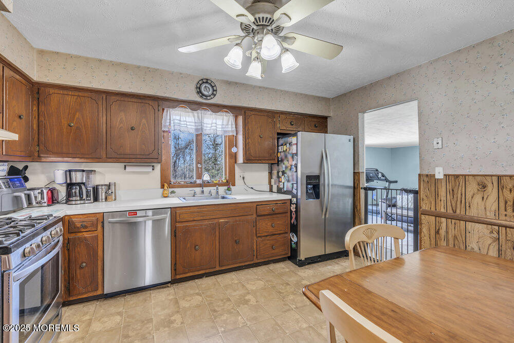 4 Koosman Drive Middletown, NJ 07737 - Photo 18 of 27 a kitchen with stainless steel appliances granite countertop a refrigerator a sink dishwasher a stove and white countertops with wooden floor
