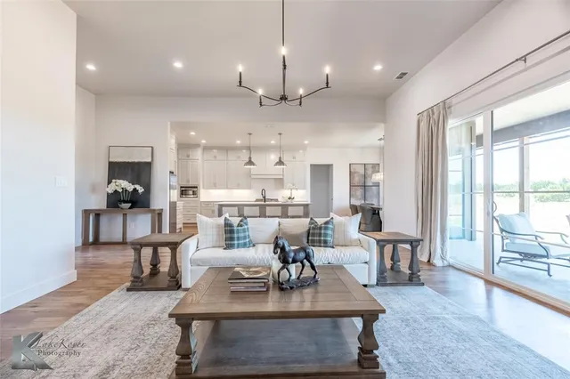 a living room with fireplace furniture and a large window