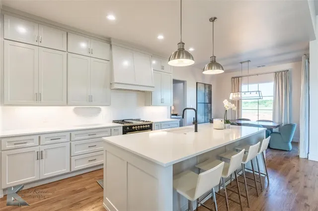a kitchen with a table chairs sink and cabinets