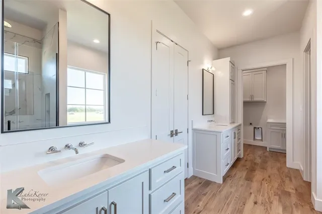 a bathroom with a double vanity sink a mirror and a bathtub