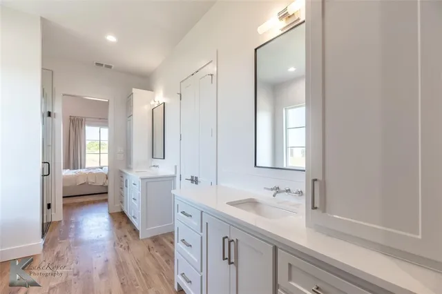 a spacious bathroom with a double vanity sink a mirror and a bathtub