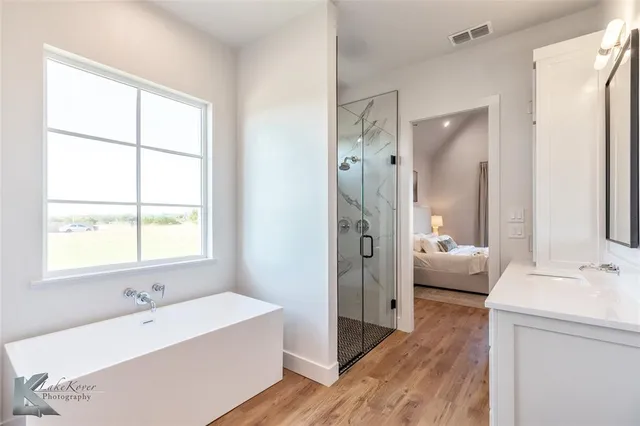 a bathroom with a tub sink and mirror