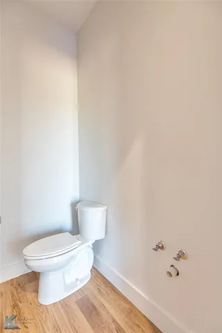 a white toilet sitting next to a white wall
