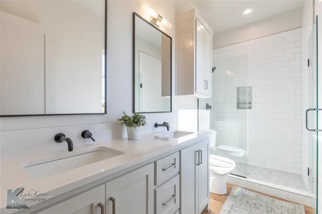 a bathroom with a sink a toilet and a large mirror