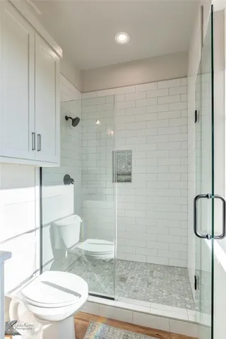 a bathroom with a shower a toilet and a sink